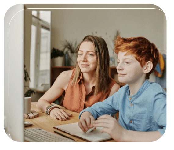 A boy and his mother sitting at a computer to learn together with online learning tools